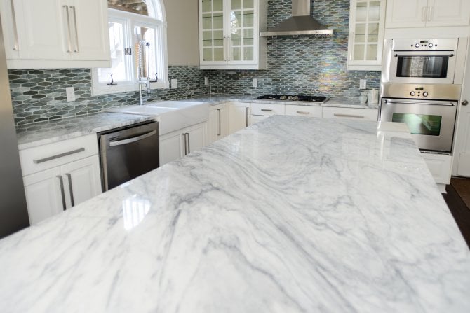 Kitchen With White Marble Countertops And Tile Backsplash