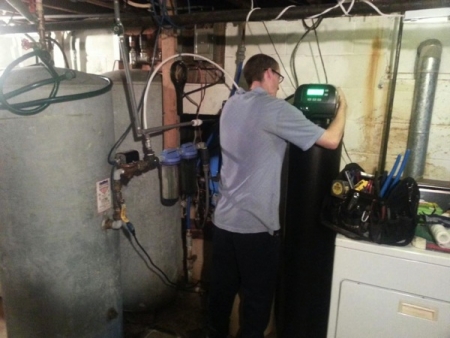 Service technician Jason Amerson installs a water softener in a Columbus-area home. (Photo courtesy of Robert Miller)