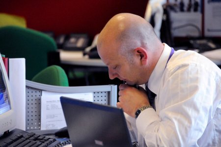 A man talking on a phone in an office.