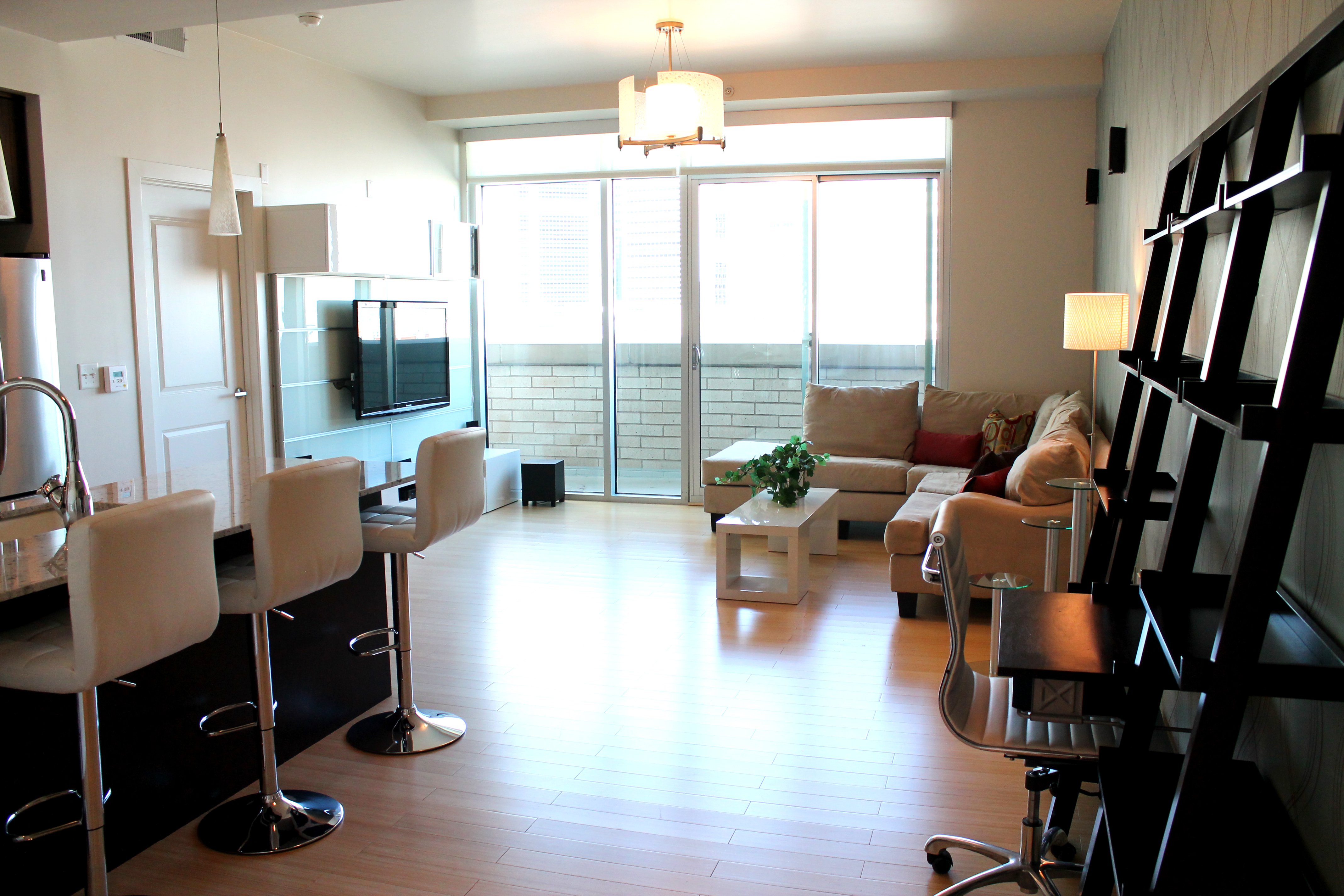 Living Room Lighting Ideas A living room area next to a bar with bar stools and a ceiling-mounted