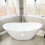 Large soaking bathtub shaped like basin inside bathroom