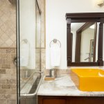 Travertine tile shower and marble countertop in bathroom