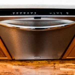 Dishwasher installed beside oak cabinets.