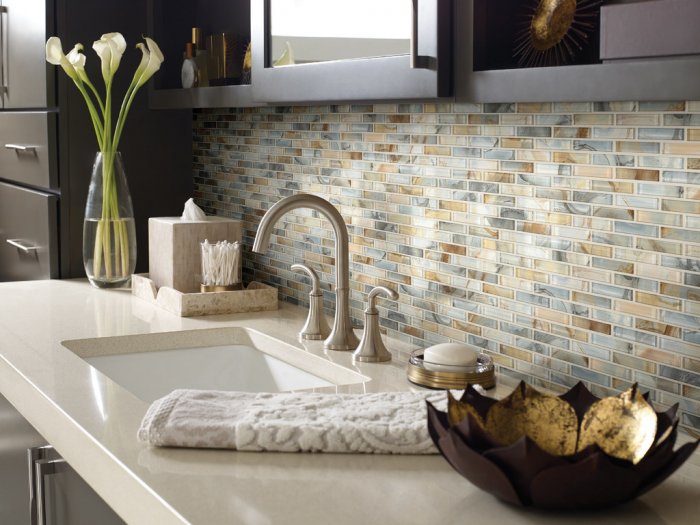 The blue tones of this tile backsplash complement the tans and browns of the other tiles, the counter and the cabinets. (Photo courtesy of Shaw Floors)