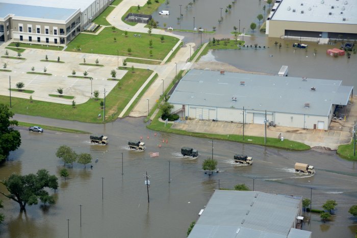 Army National Guard vehicles driving down flooded highway