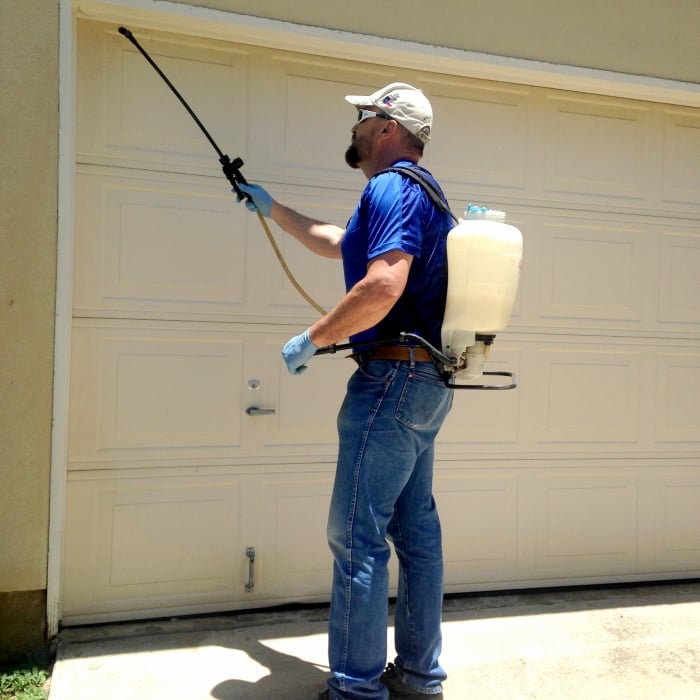 technician spraying garage for pests