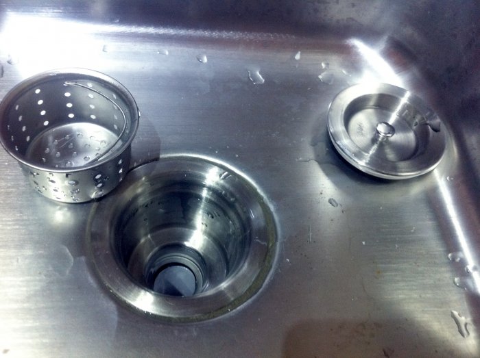 The drain of a stainless steel kitchen sink