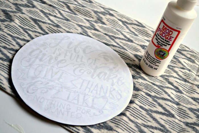 Place the paper with a thick layer of mod podge face down on your plaque so you can see the words are going from left to right. (Photo by Abbey DeHart/The Cards We Drew)
