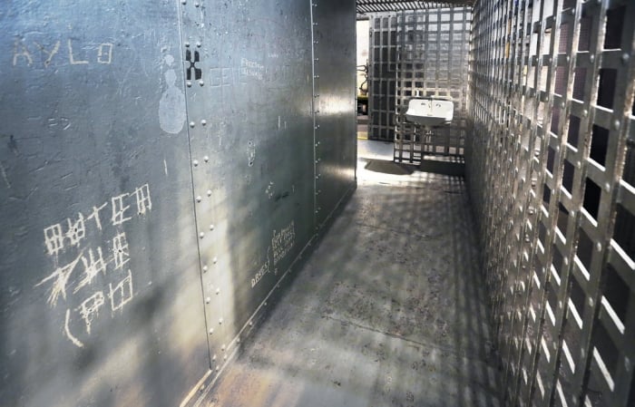 an old jail with bars and a sink