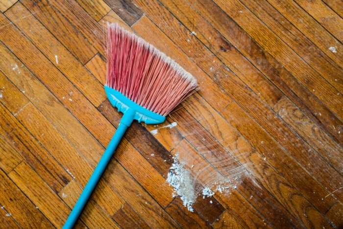 broom on dirty, dusty wood floor