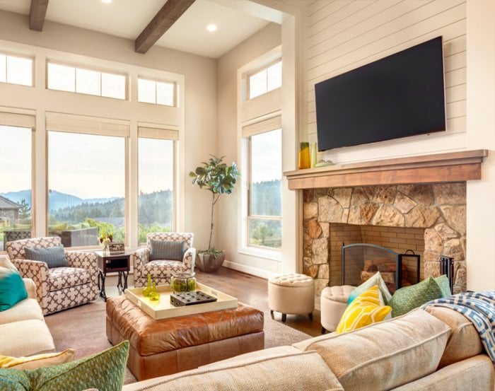 TV mounted above wood and stone fireplace mantel