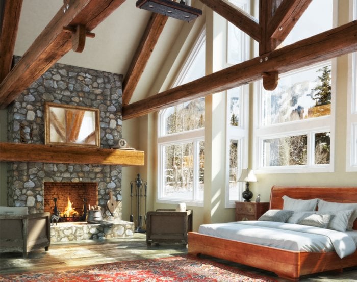 Stone fireplace in bedroom with high ceiling