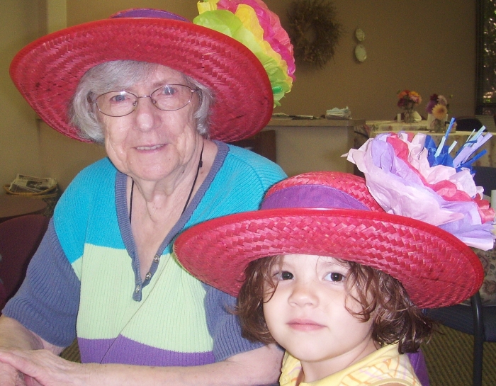 senior woman playing dress up with female child