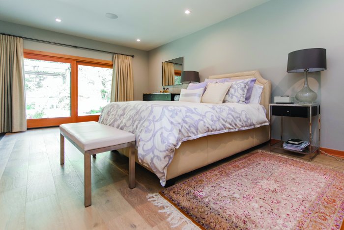 master bedroom with upholstered headboard and purple bedding