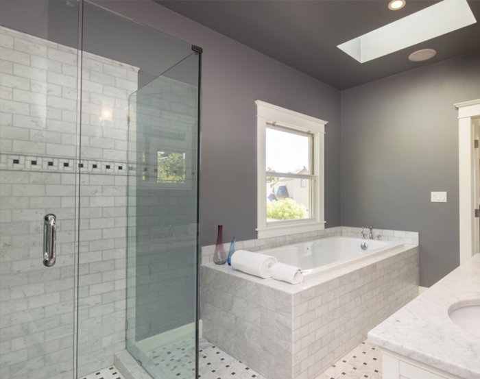 Frameless shower door alongside tiled bathtub