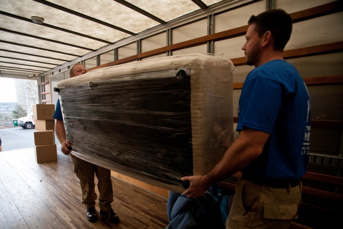 Movers loading a couch into a moving truck