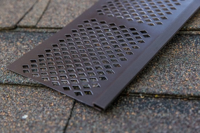vinyl gutter guard sitting on asphalt roof