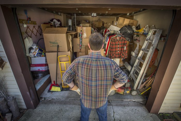 Guy staring into garage packed with boxes and other items. Guy staring into garage packed with boxes and other items.