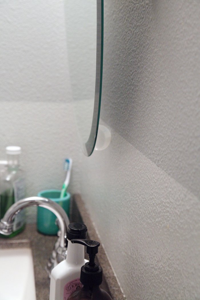 The bathroom mirror wouldn't stay upright, forcing some creative solutions. (Photo courtesy of Jennifer Jones/iHeart Organizing)