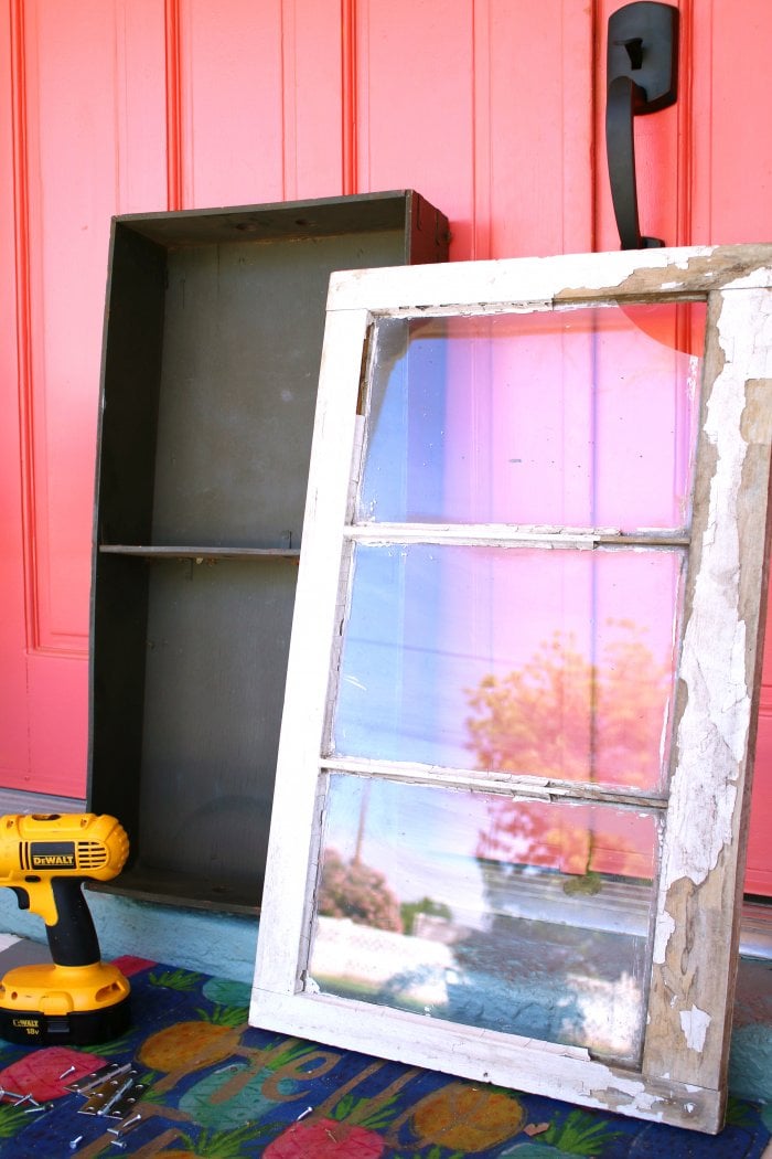 An antique trunk and a chipped vintage window make the perfect cabinet. (Photo courtesy of Lolly Jane)