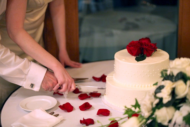 wedding photo of couple cutting wedding cake