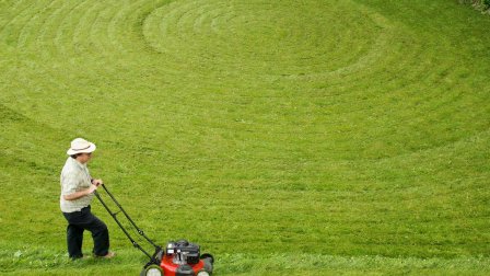 A man mowing in a circular pattern