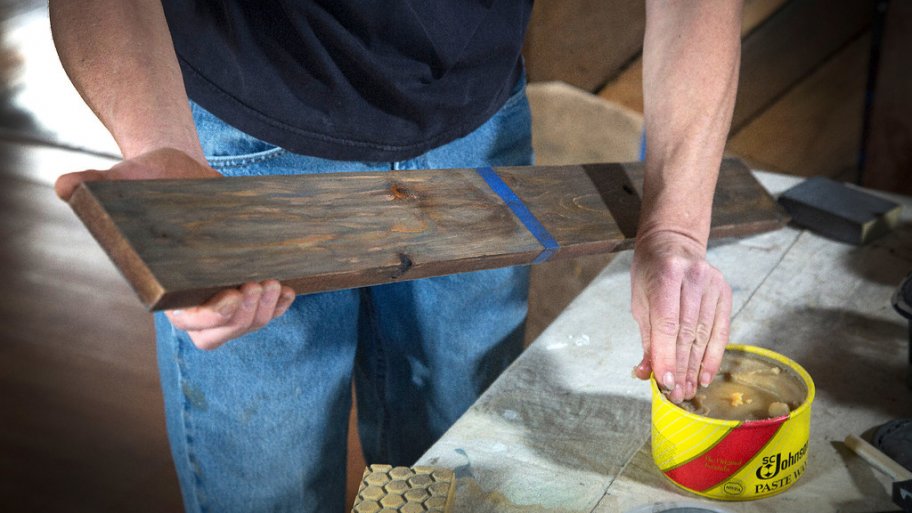 Liza Oates of Wild Zen, Inc. applies paste wax to a board altered with vinegar