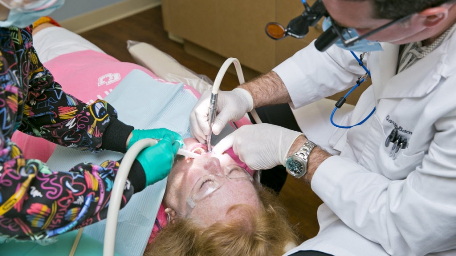 a dentist and a hygenist working with a patient