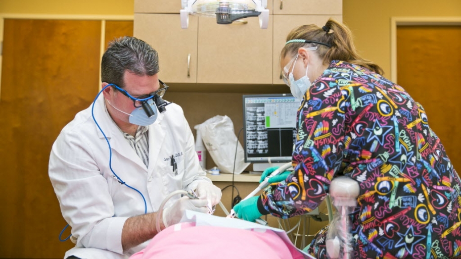 a dentist and a hygenist working with a patient