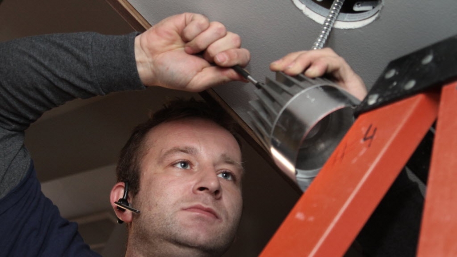 an electrician installing a light