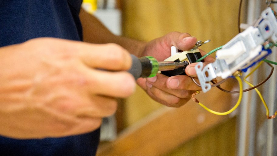 A man fiixing a light switch