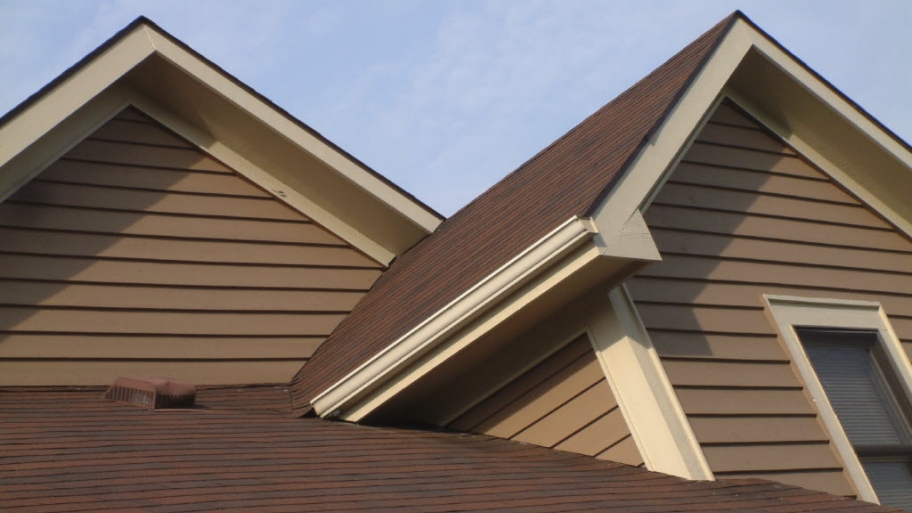 a brown house with tan siding and shingles