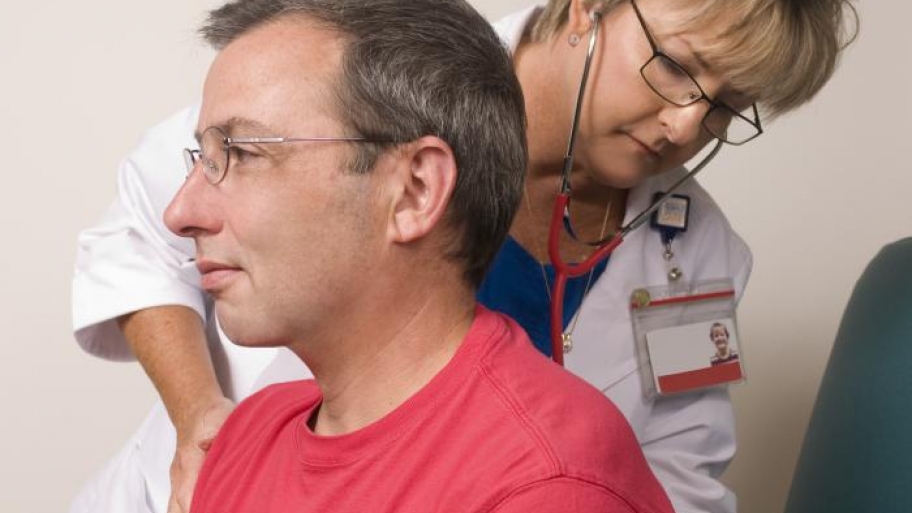 doctor with stethoscope listening to patient breathing