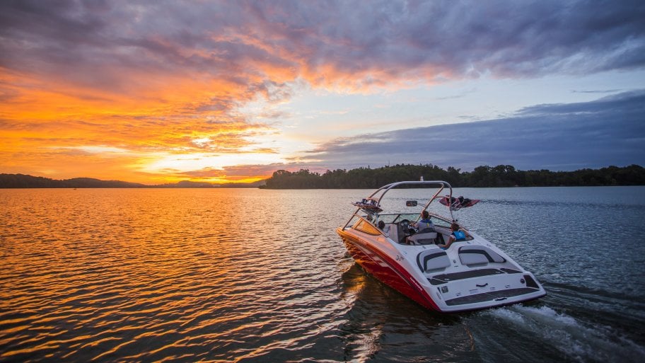 boat on water red speed boat on lake at sunset