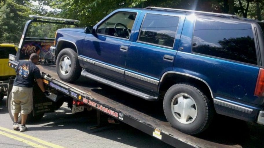 large SUV being hooked onto a tow truck
