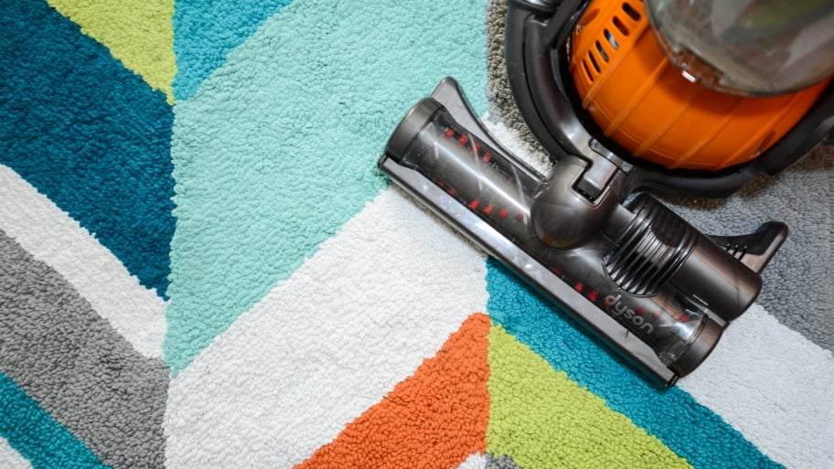 vacuum cleaner on multicolored carpet