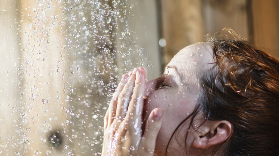 Closeup for woman washing her face in the shower