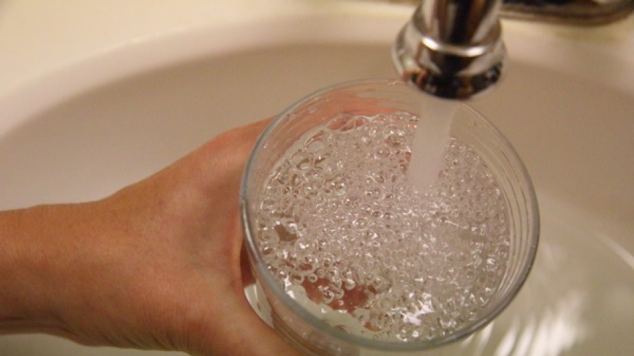 holding glass under running faucet