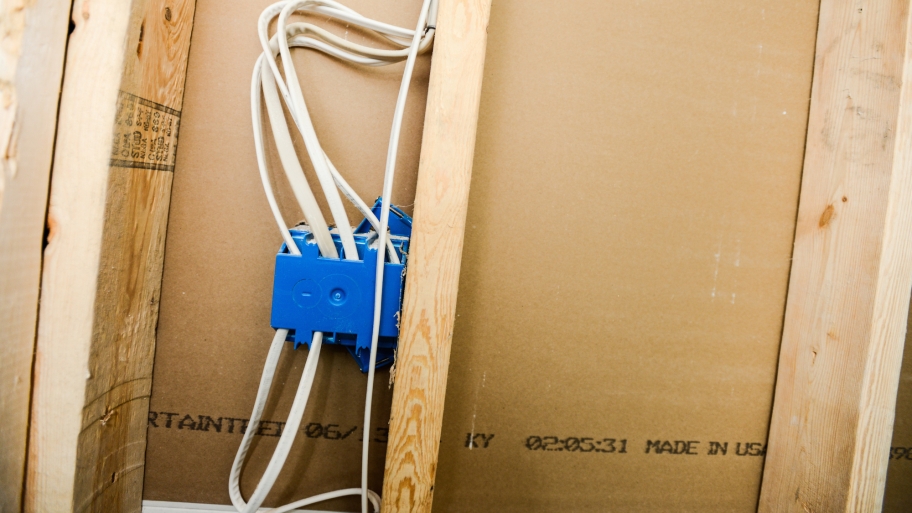 electrical wires and box inside wall with exposed studs