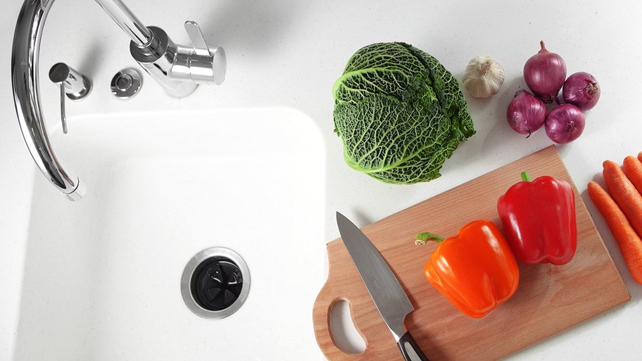 How To Install A Garbage Disposal Angie S List Garbage Disposal In Sink With Vegetables And Knife On Cutting Board