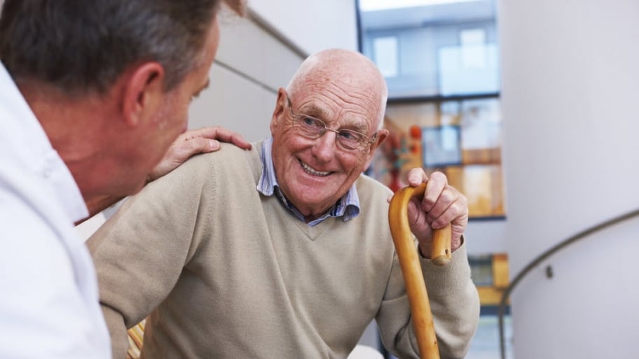 Senior man sits has a friendly conversation with a doctor