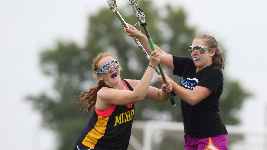 two girls playing lacrosse wearing mouthguards