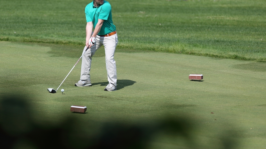 golfer teeing off