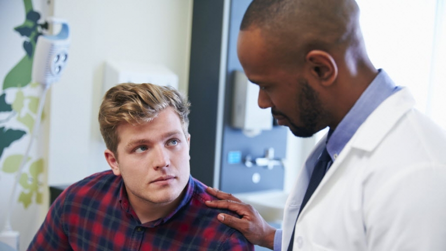 doctor talks to adult male patient