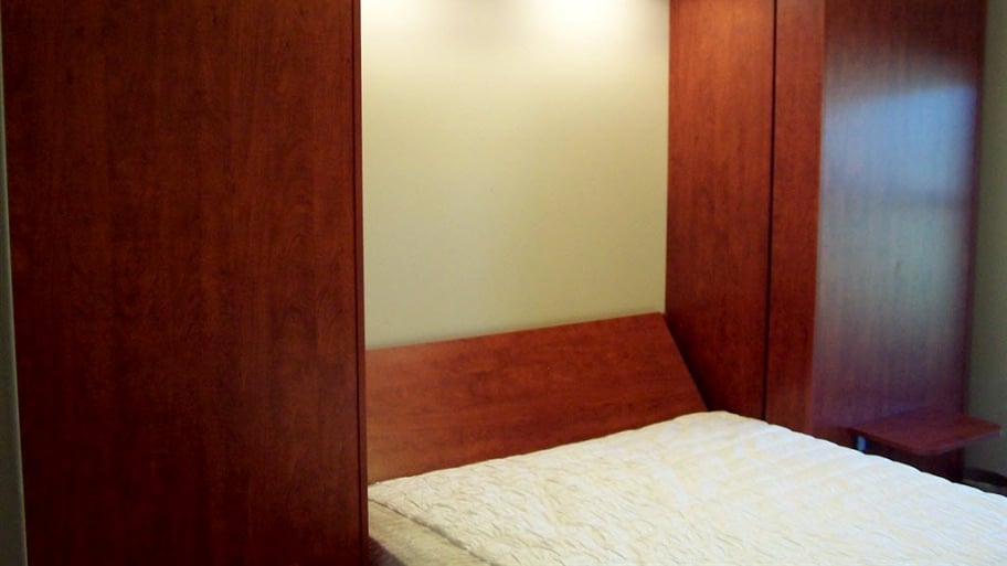 a murphy bed that folds into a wood cabinet