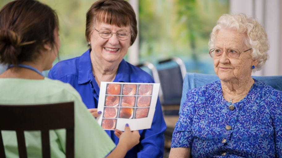 Female doctor visits elderly female patient in nursing home