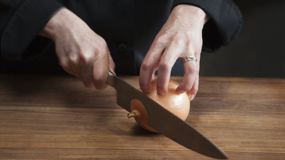 chopping an onion on cutting board