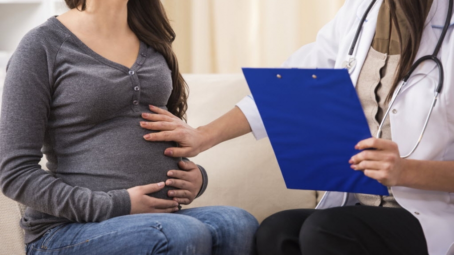 A pregnant woman speaks with her doctor