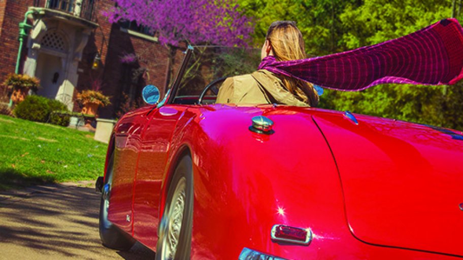 red convertible with woman driving and scarf flying