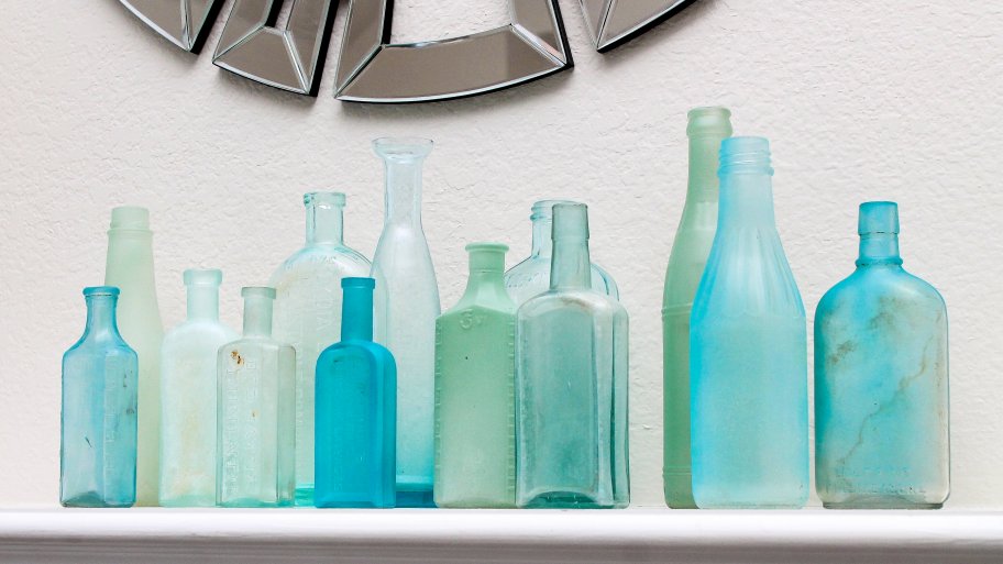 grouping of blue and green sea glass bottles